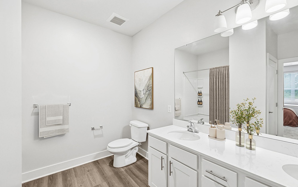 bath with vanity and large mirror