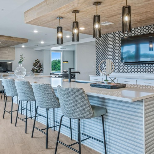 Settle into comfort at Attain at Bradford Creek a kitchen with a bar and chairs